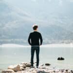 A man looking at river and mountains. Image is used for highlighting stimulating quotes.