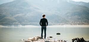 A man looking at river and mountains. Image is used for highlighting stimulating quotes.