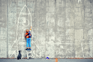 How to Think Big-a child on a ladder drawing a rocket on a wall