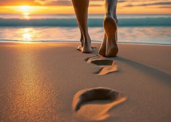 Girl walking barefoot on a beach at sunset, with waves lapping at the shore - Mindfulness